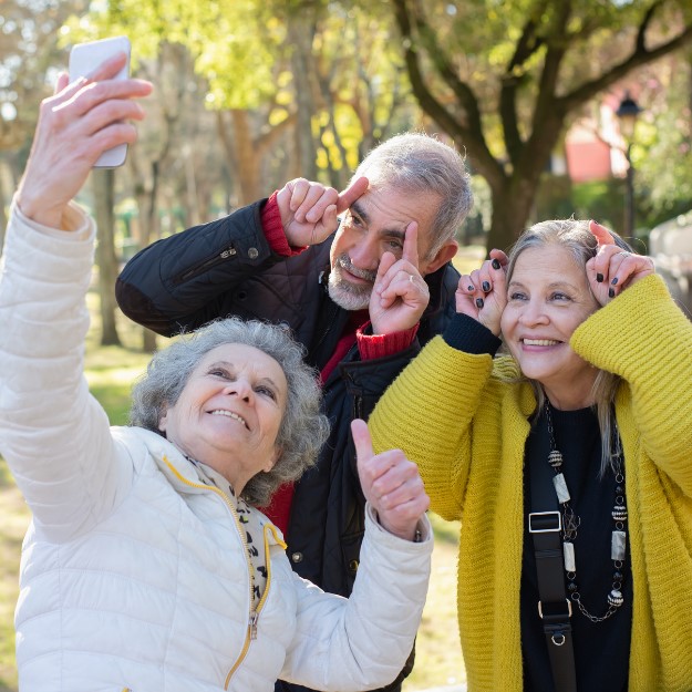 Three people taking a selfie standing in a park