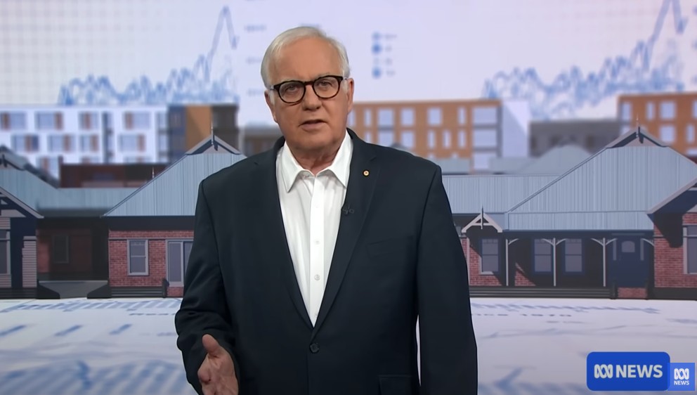 Alan Kohler presenting in front of a housing backdrop