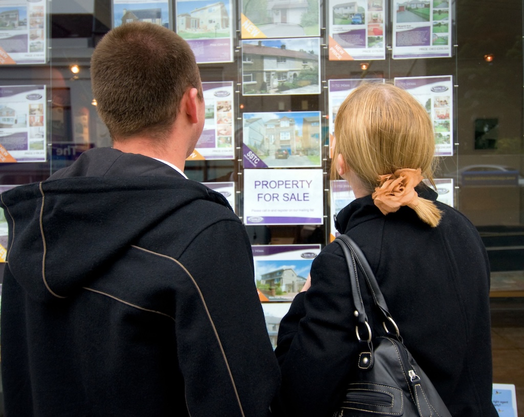 A couple looking in a real estate office window. Photo Nick Gregory, Alamy
